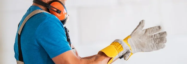 Person zieht Arbeitshandschuh an